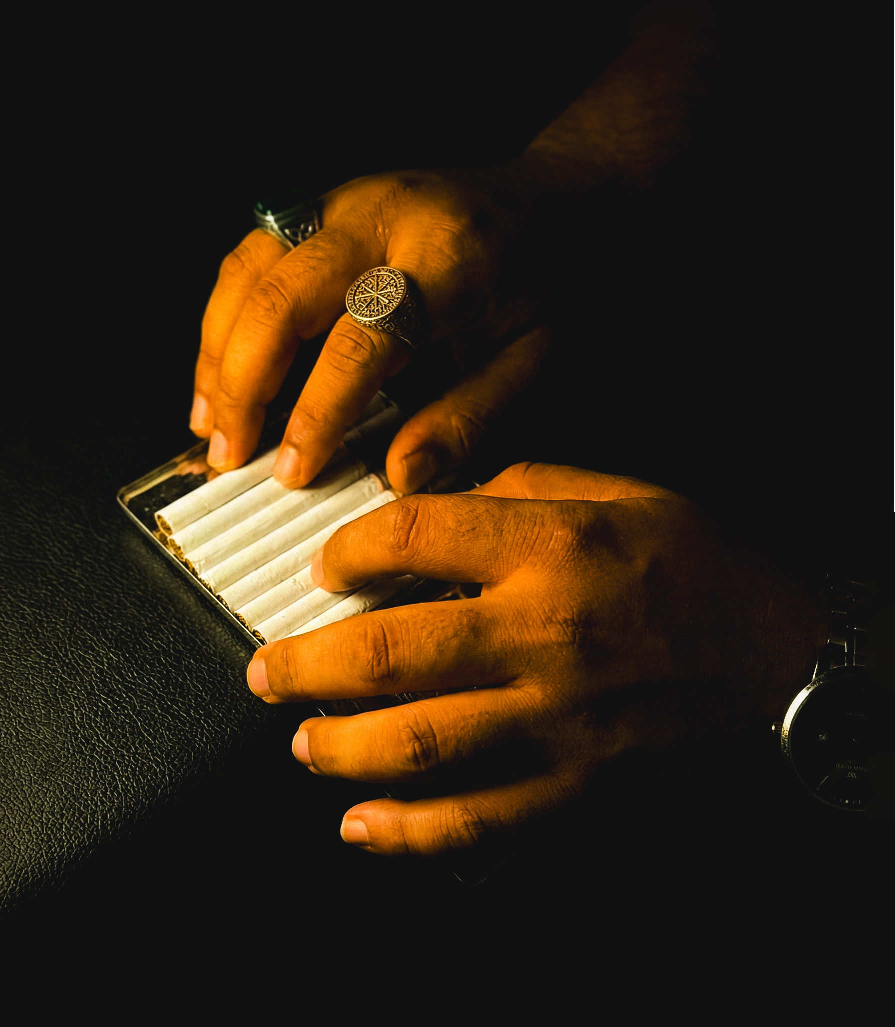 The Metal — silver signet ring and lighter on dark surface